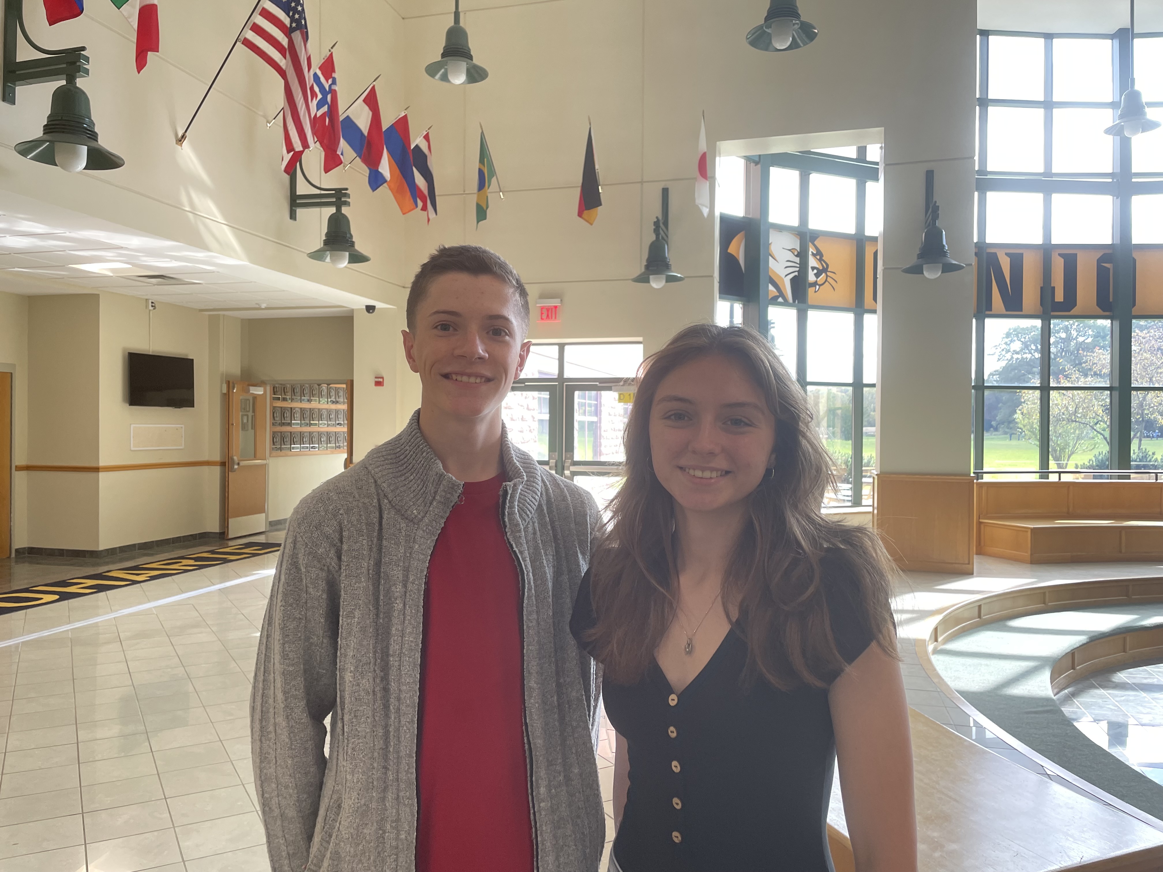 Two students stand in the lobby of the high school.