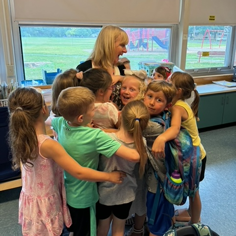 Students hug their teacher