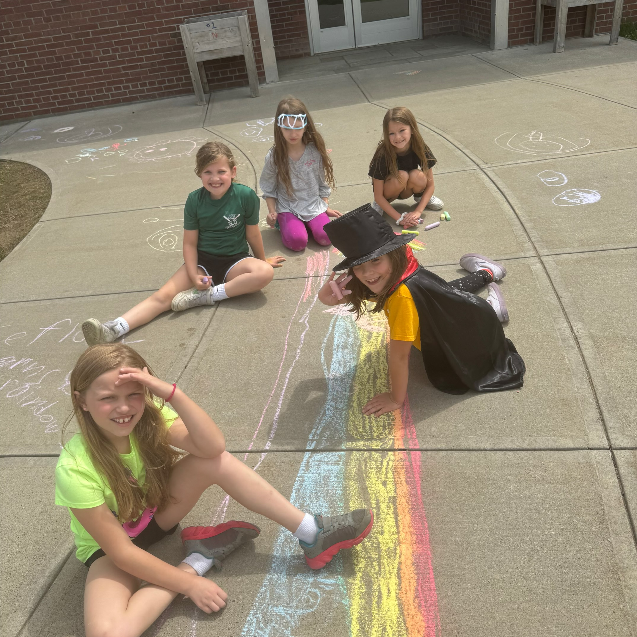 Five students create a chalk drawing on Kindness Day