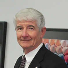 William Elder stands against a white wall. 