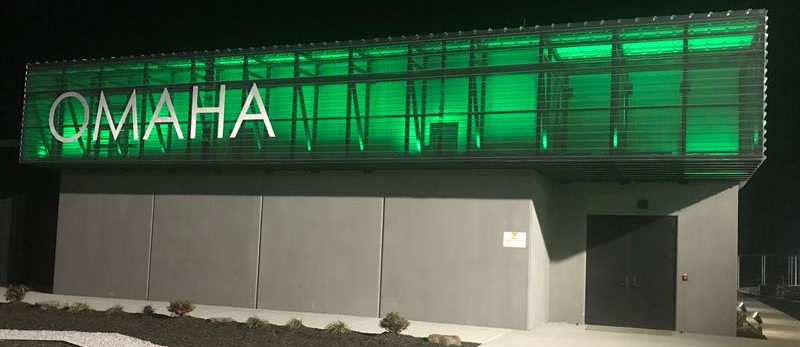 new omaha school building at night with green lighting