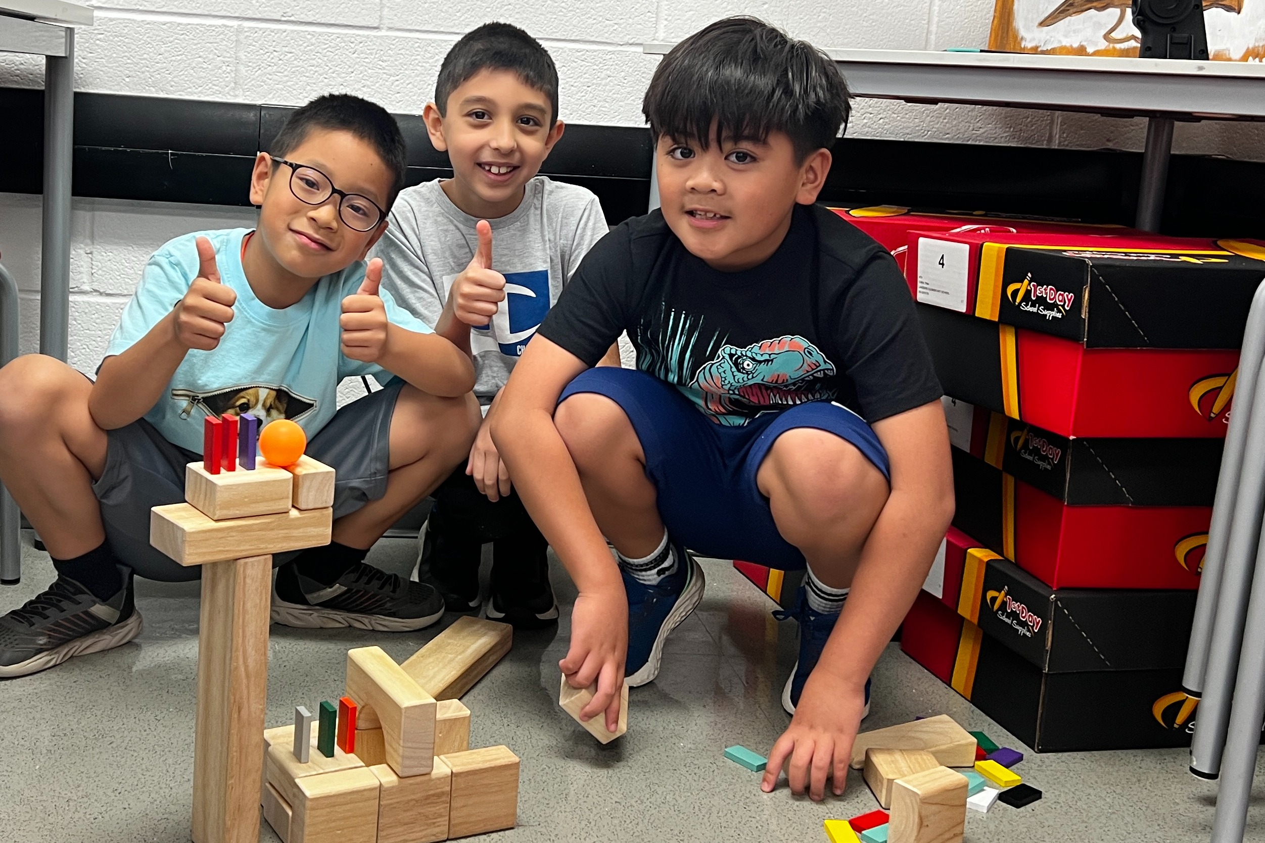 This image is of three third grade learners building with blocks during their STEAM class.