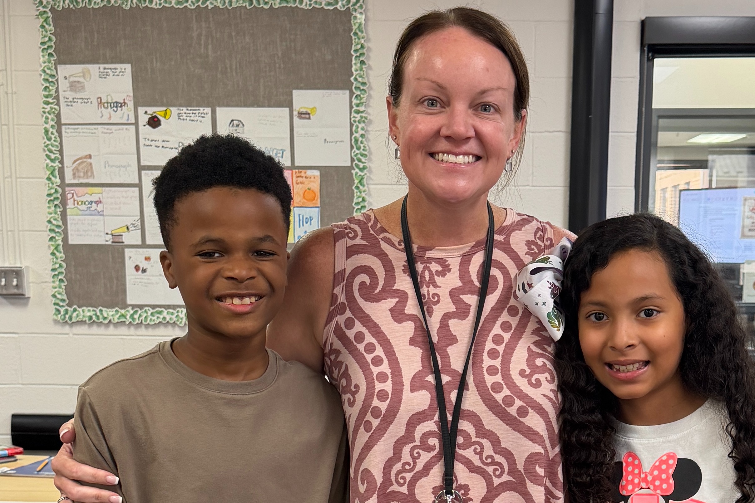 The image is of Mrs. Bailey, a fifth grade teacher, and her two  students.