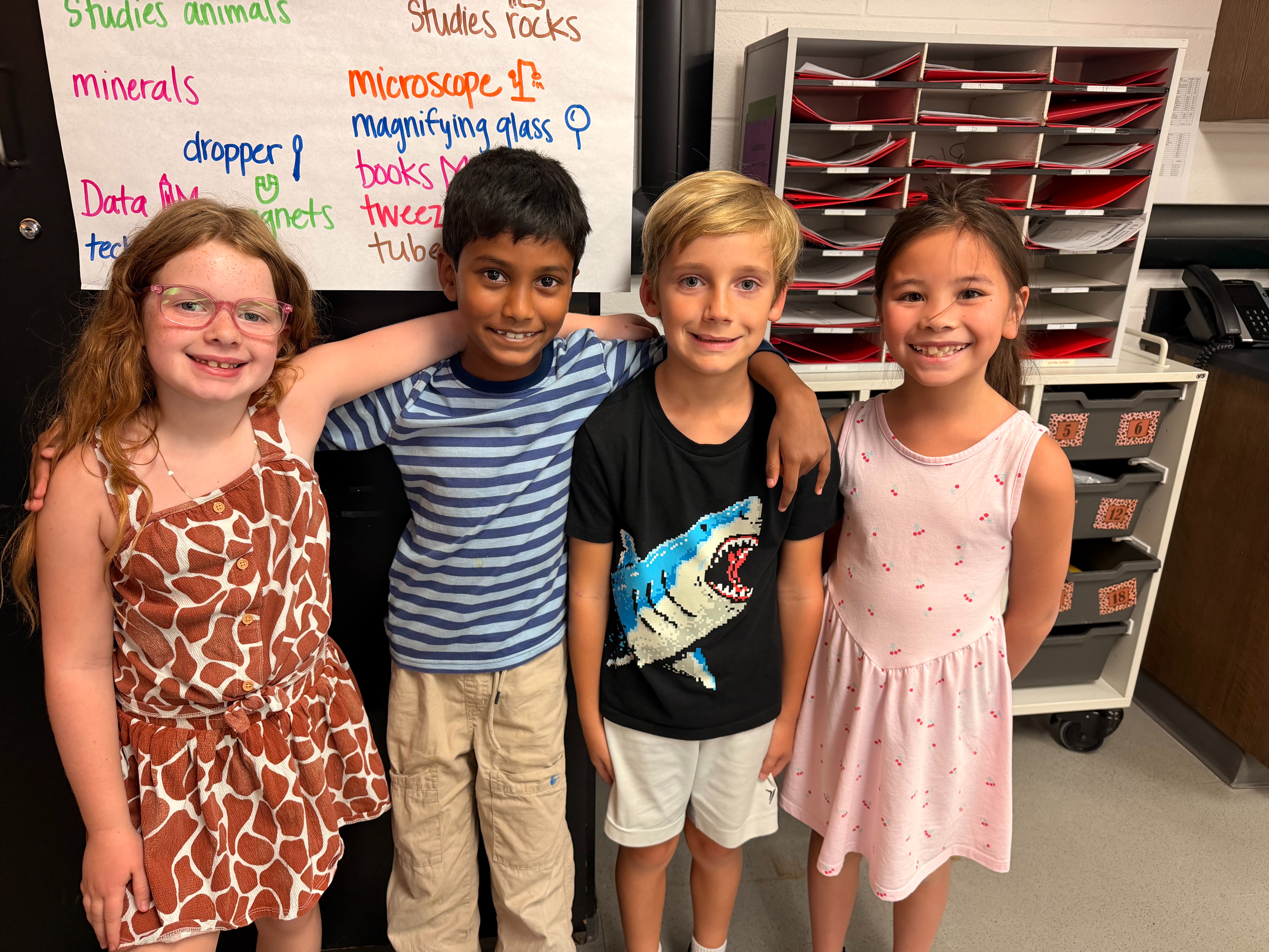 This image shows four second grade learners standing side by side during their math class.