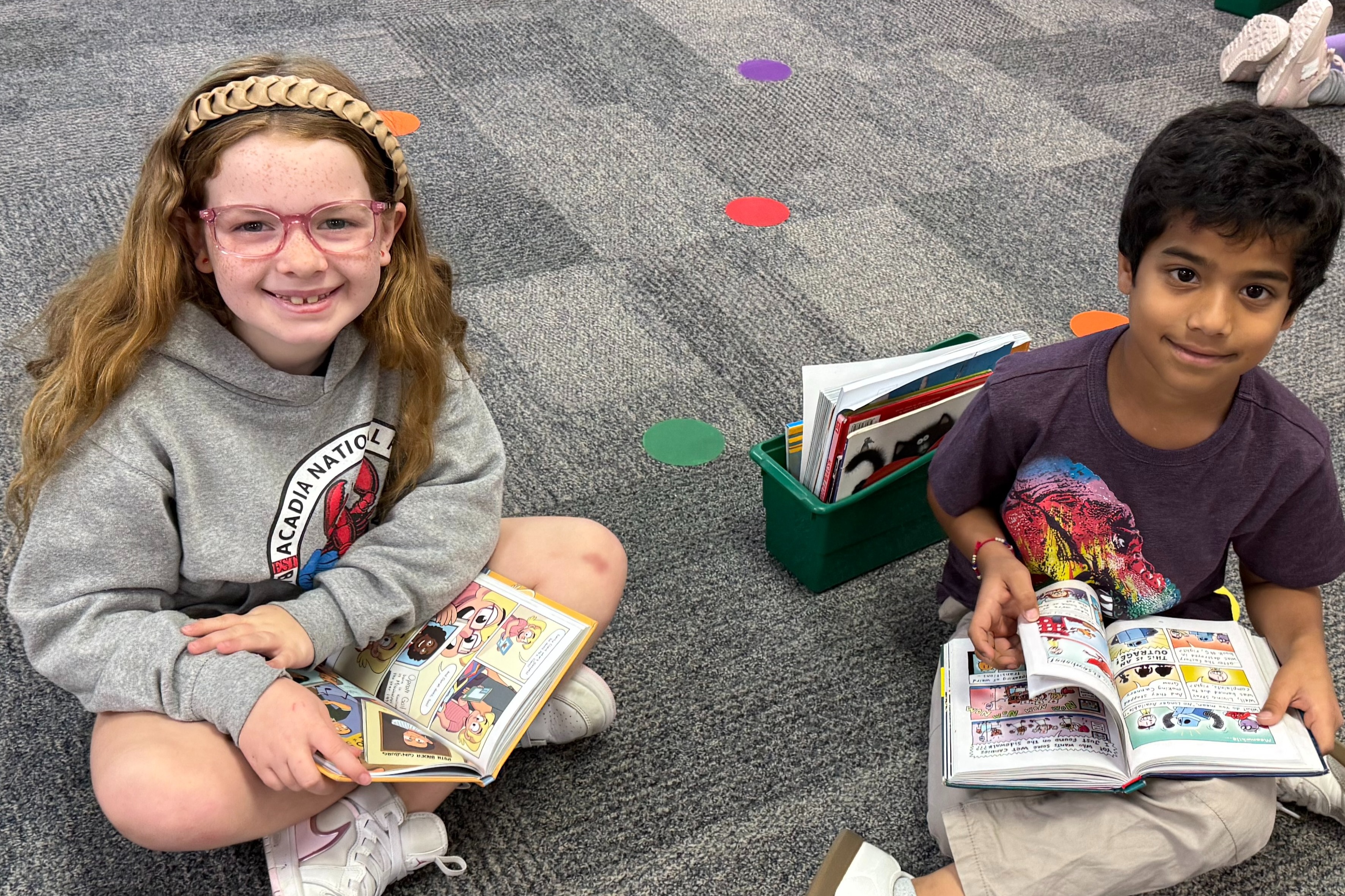 This image shows two second grade learners sitting on the floor reading independently in their ELAR class.