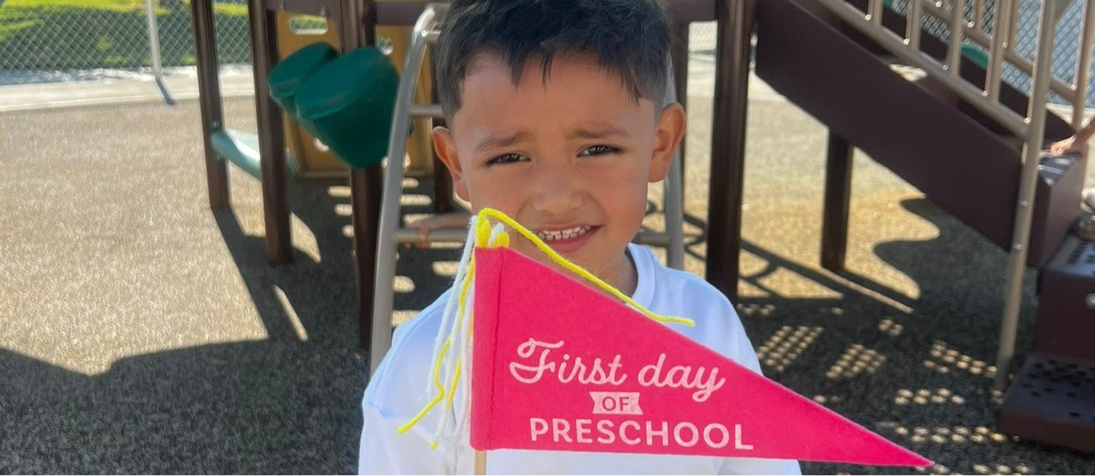 rssp student with first day of preschool flag