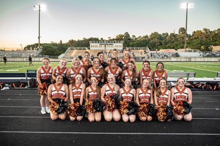 Cheer team poses under the Friday night lights during the 2022 season.