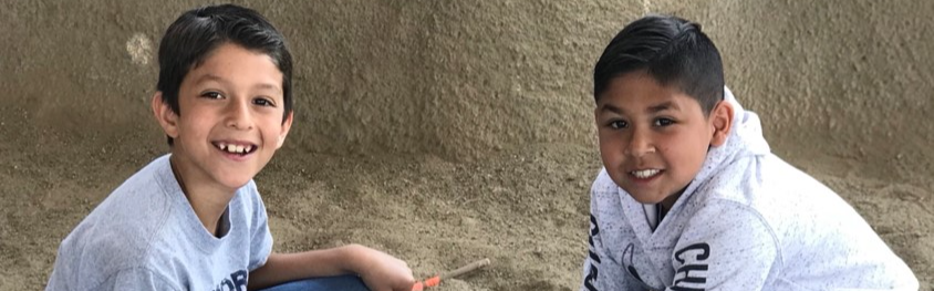 two students digging in sand