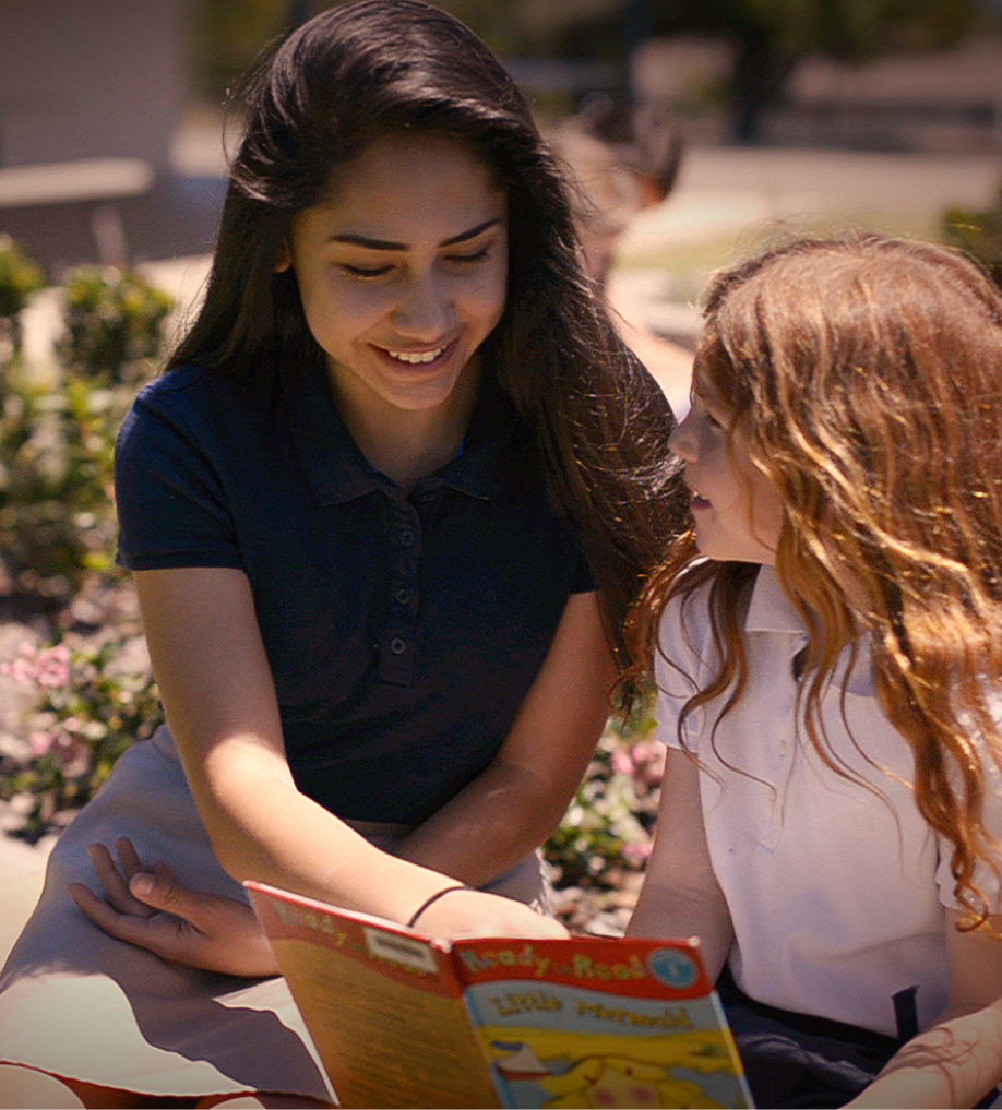 student reading to another student