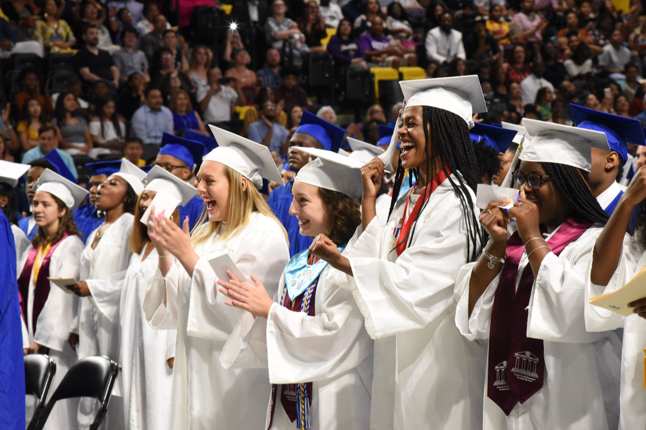 Graduation ceremony with graduates celebrating.