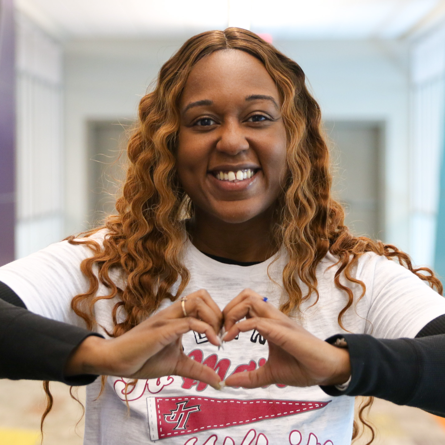 Photo of Dana Sykes making heart shape with hands