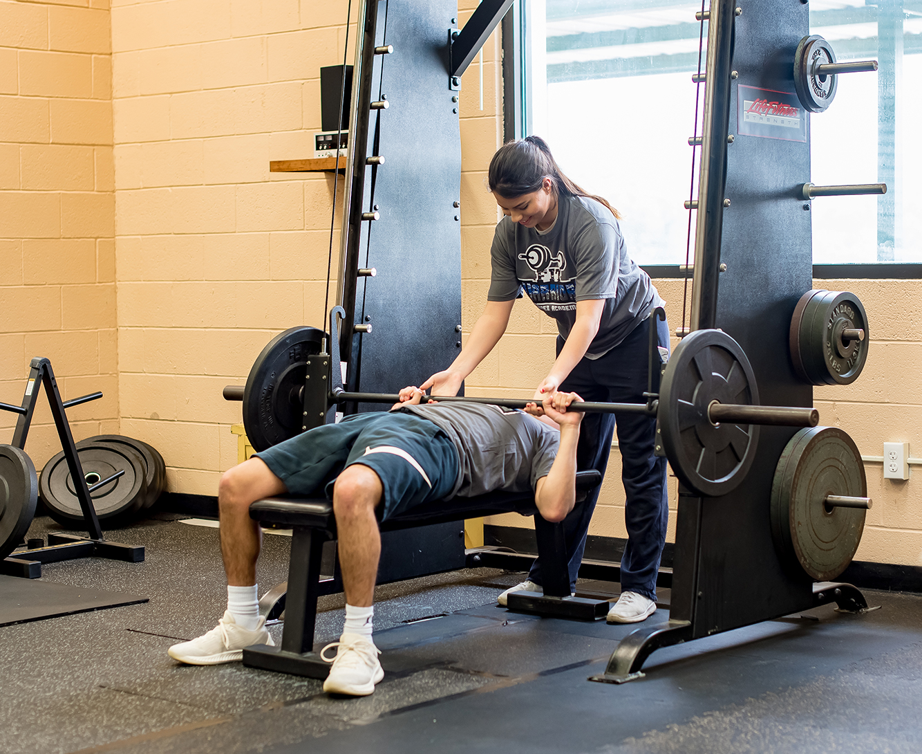 A student lifting weights in the gym