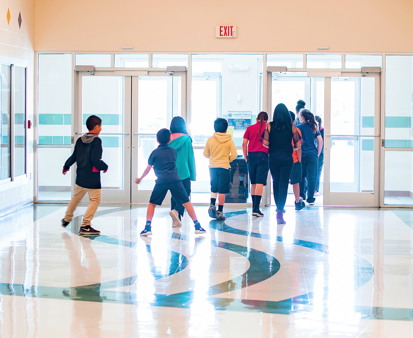 Elementary students walking into their school building