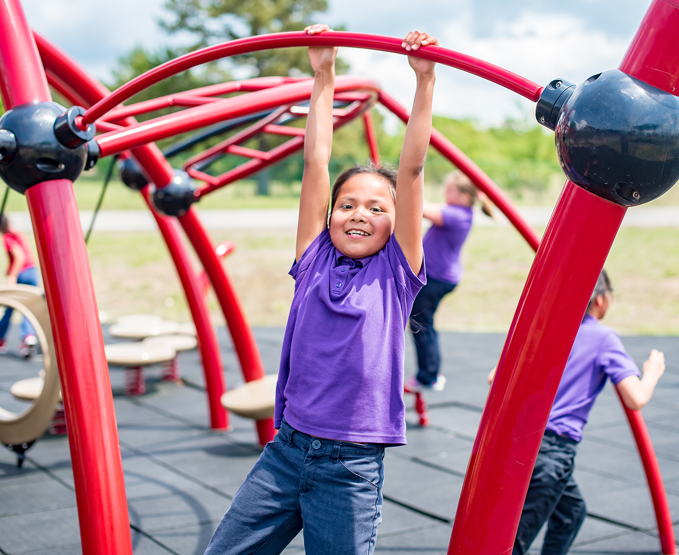 A student playing on playground equipment