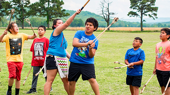 Students playing stickball in a field