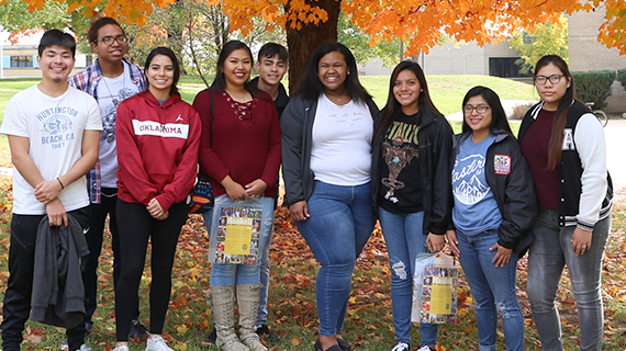 A group of students standing outside and taking a group picture