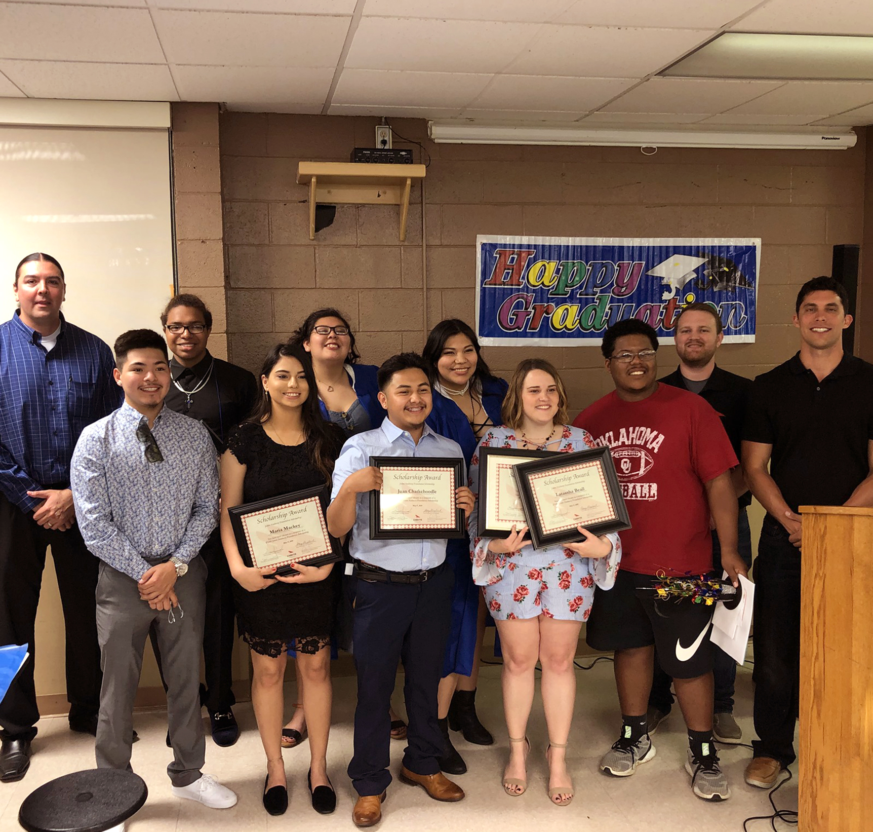 Students taking a group photo while holding scholarship certificates