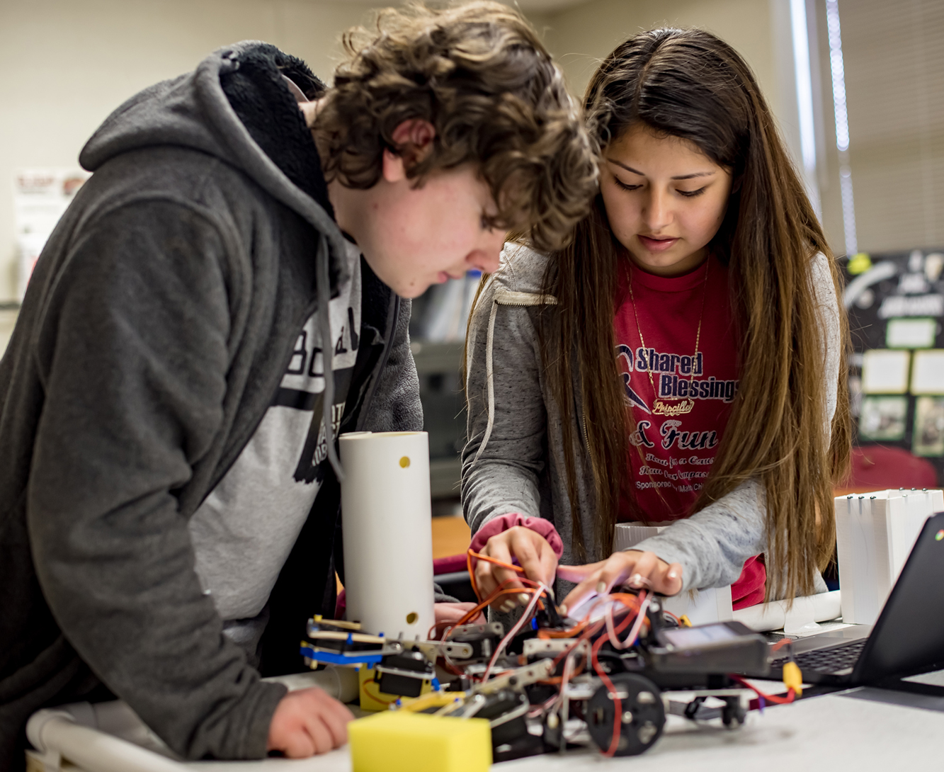 Two students working on a robot together