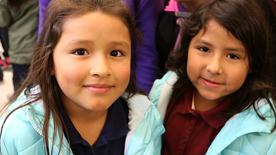 Two elementary students sitting next to each other on the floor