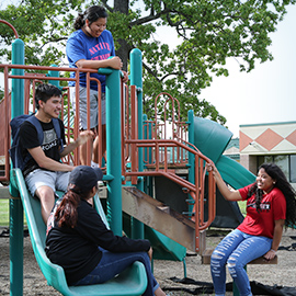 Young students playing on playground equipment