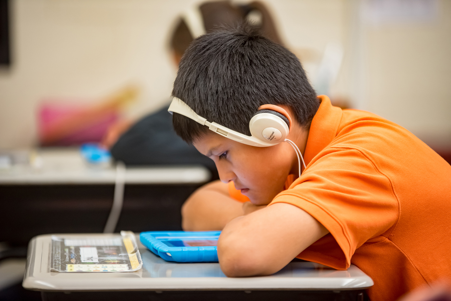 A student watching a tablet with headphones on