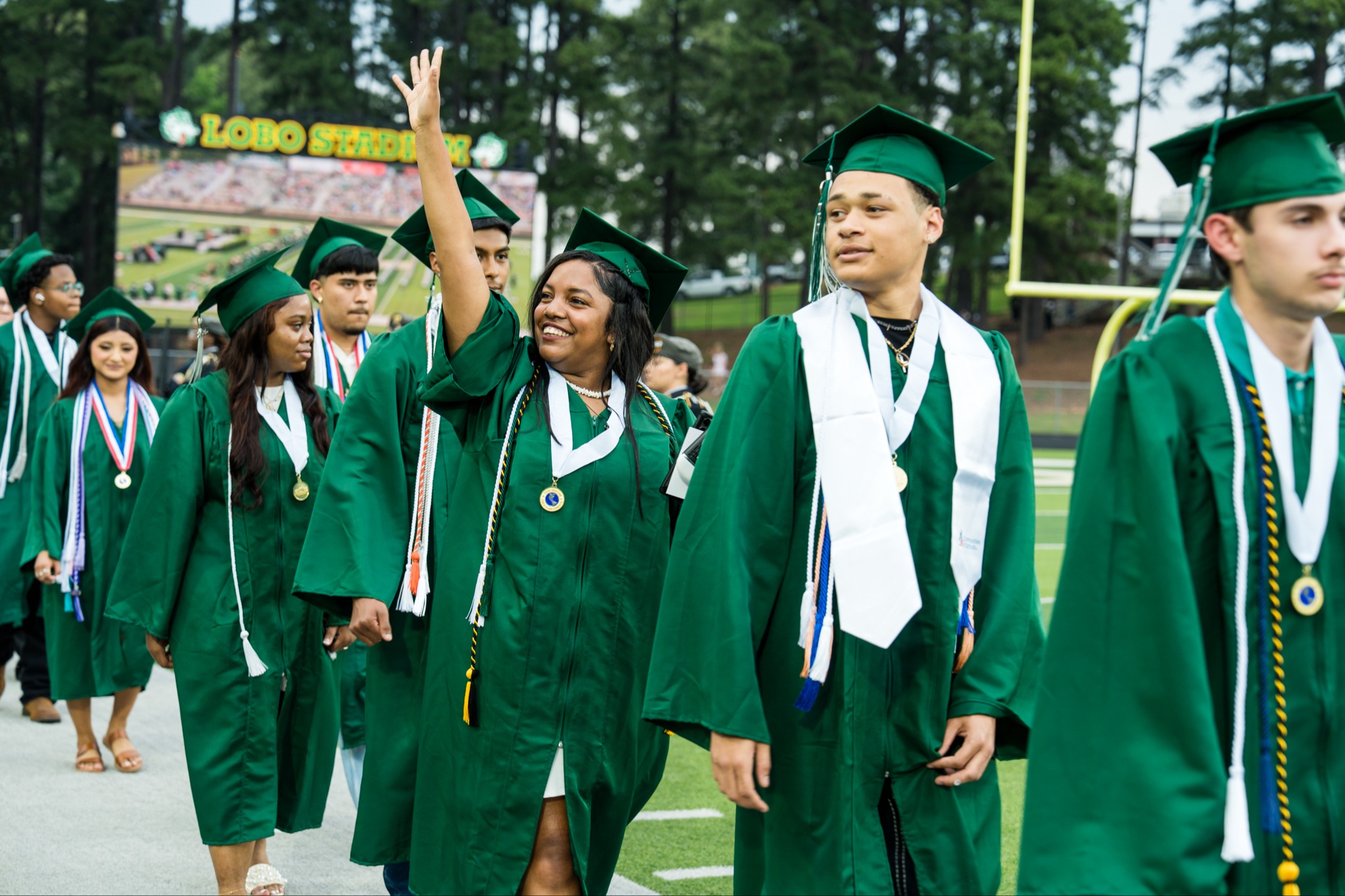 graduate waving at crowd