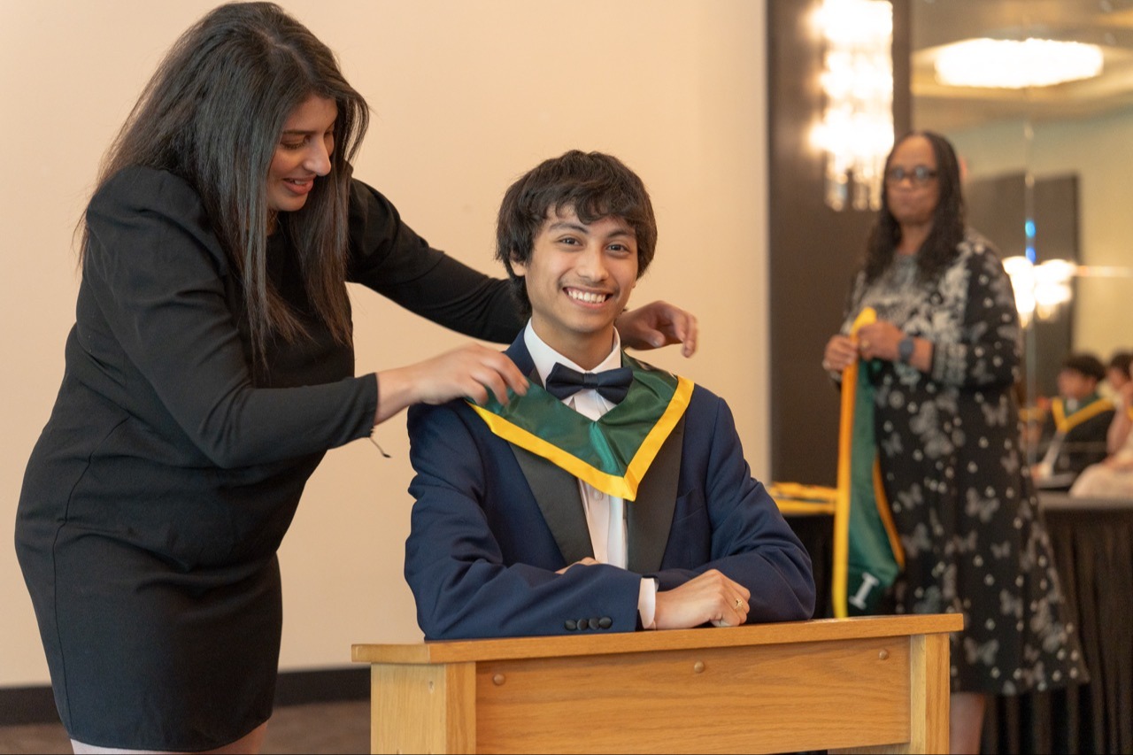 student being robed for IB ceremony