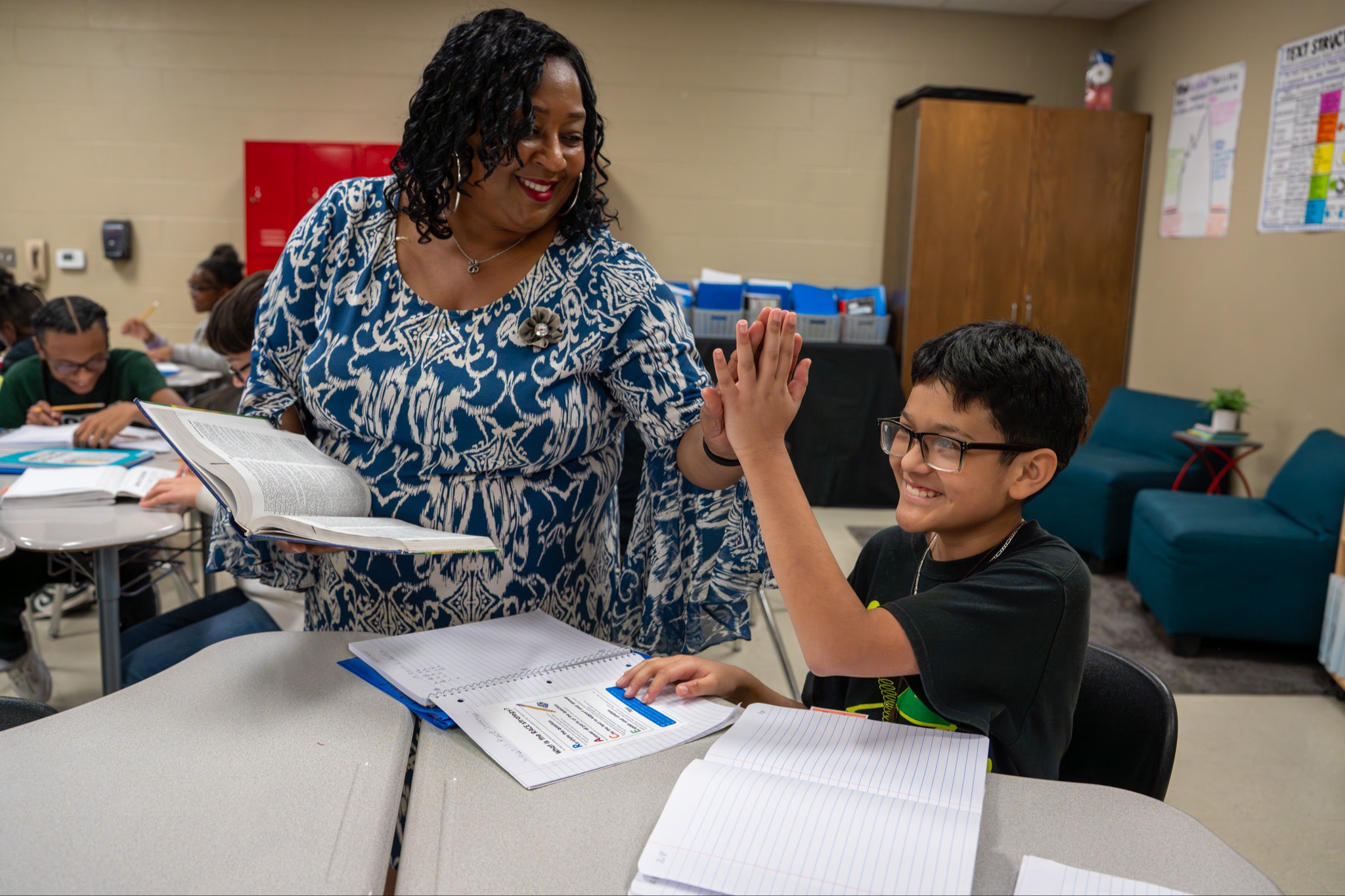 student high fiving teacher in classroom