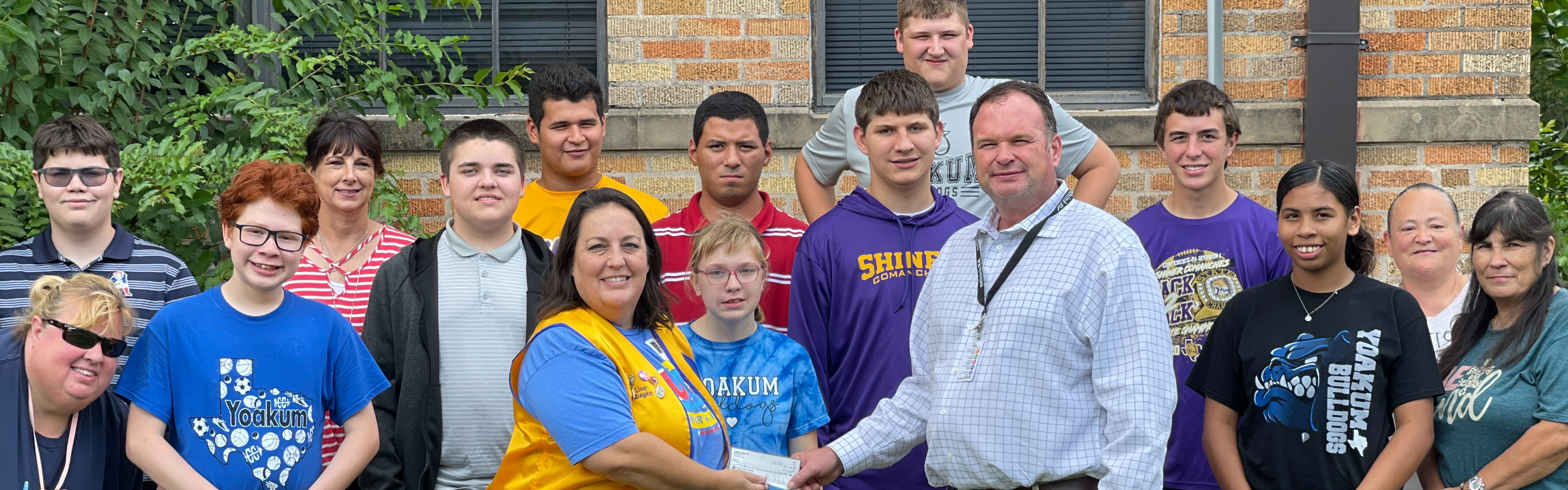 Students and Staff Receiving Donation Check from Lions Club Member