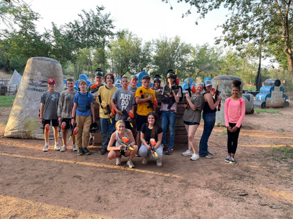group of people playing paintball standing for group photo smiling