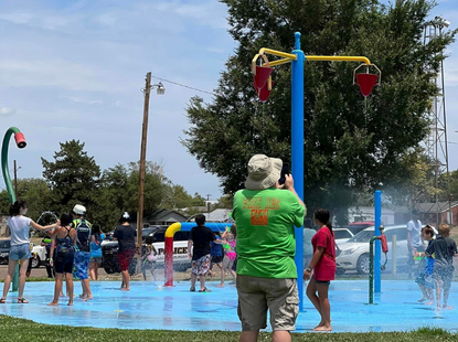 kids and adults playing in water at splash pad