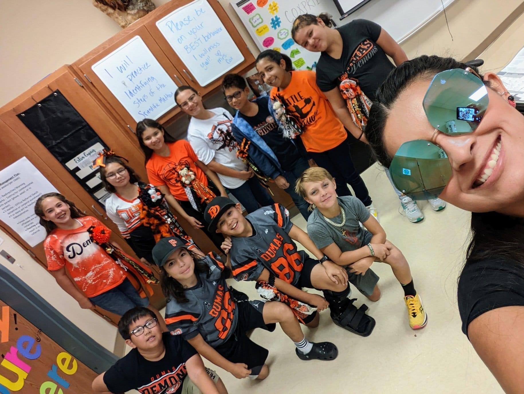 Elementary teacher posing with students for a selfie