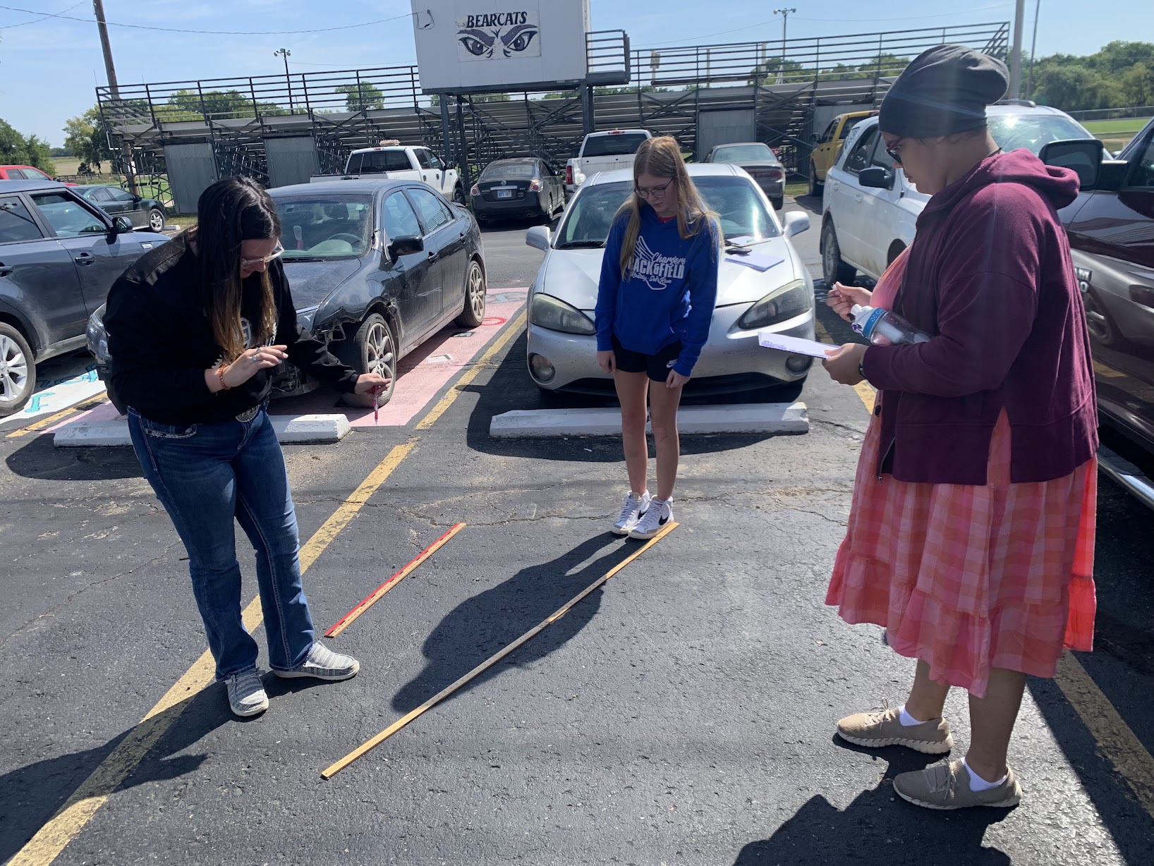 Students measuring shadow of another student. 