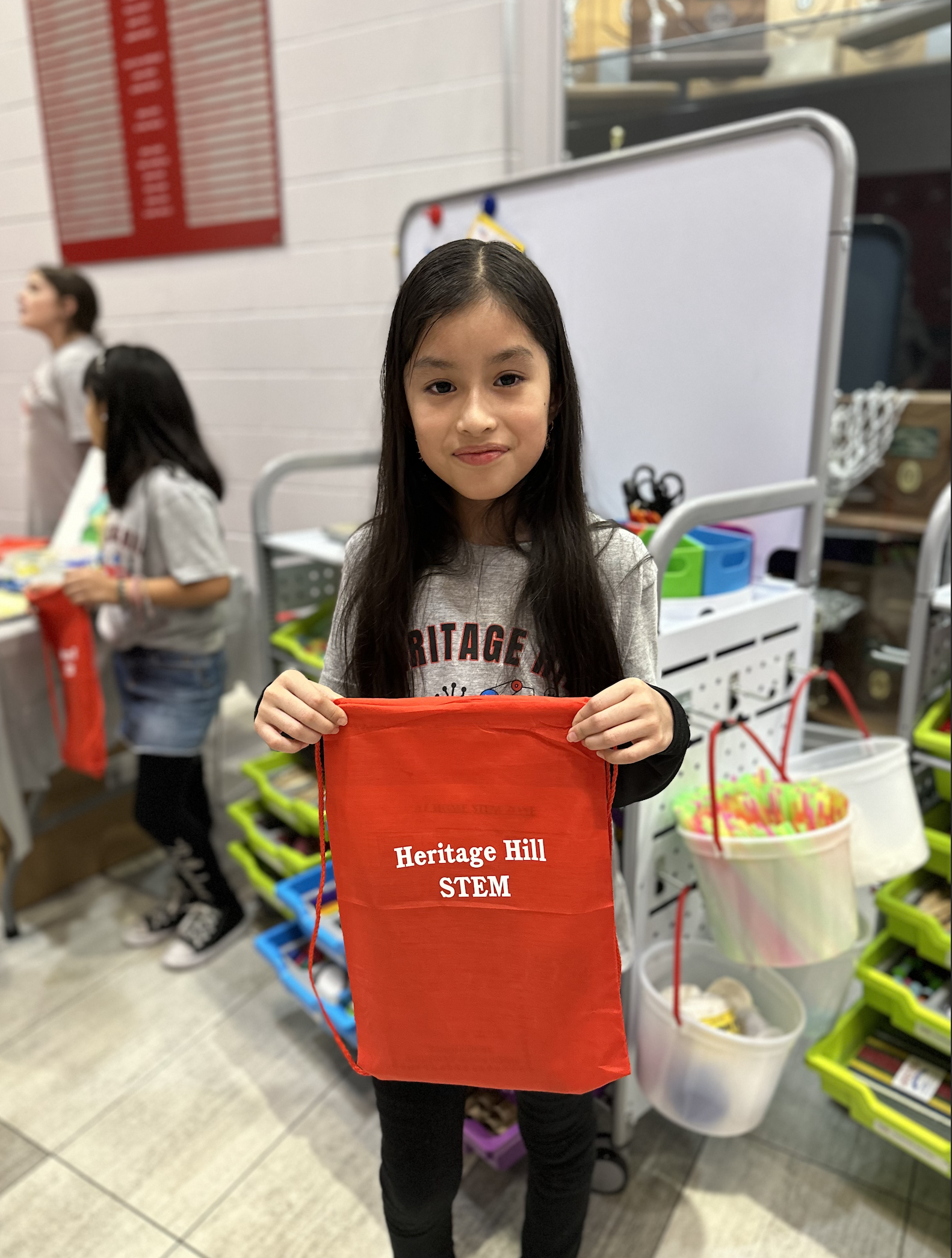 Student Achievement Fair - girl holding a red STEM bag