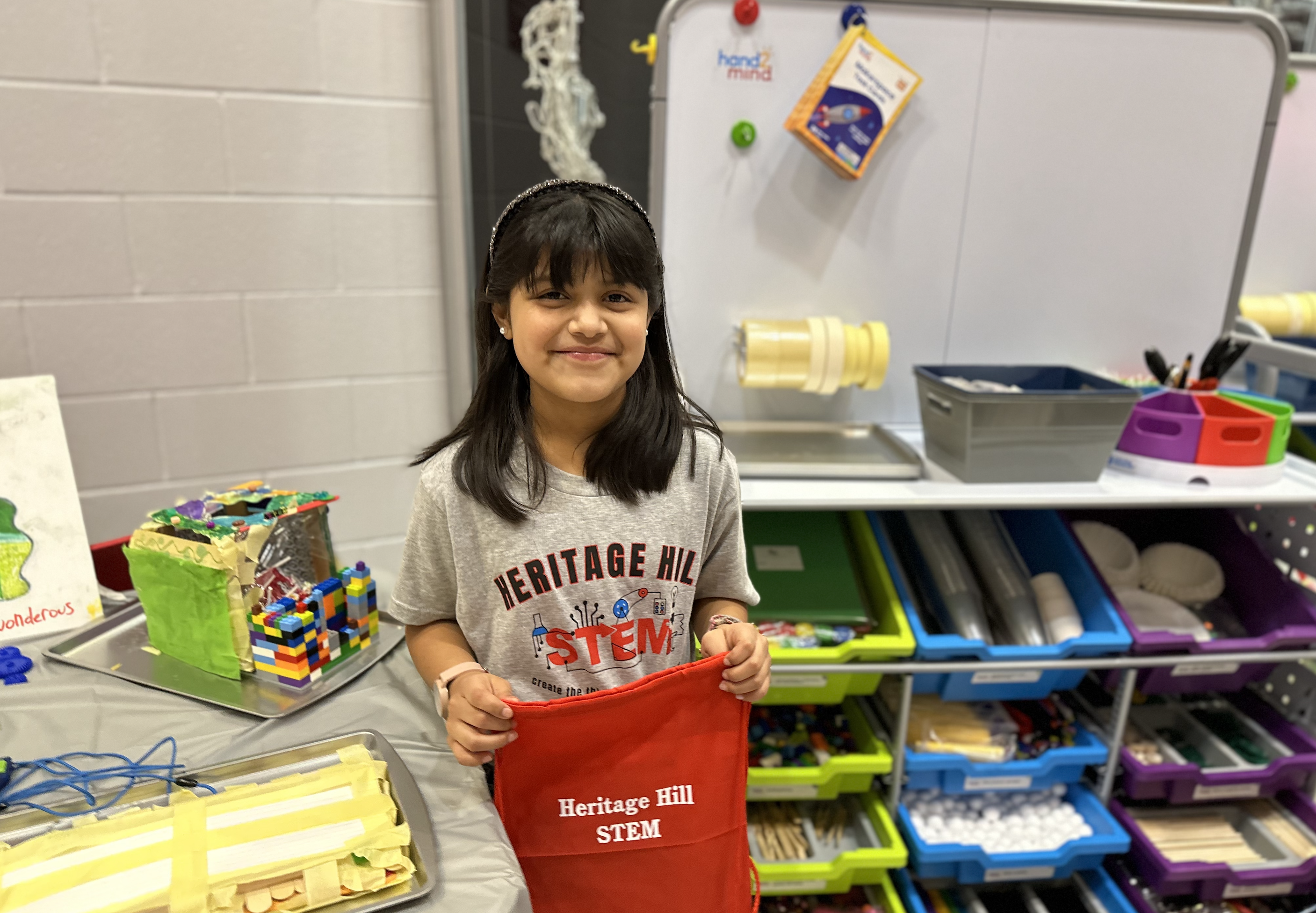 Student Achievement Fair -student holding a red STEM bag
