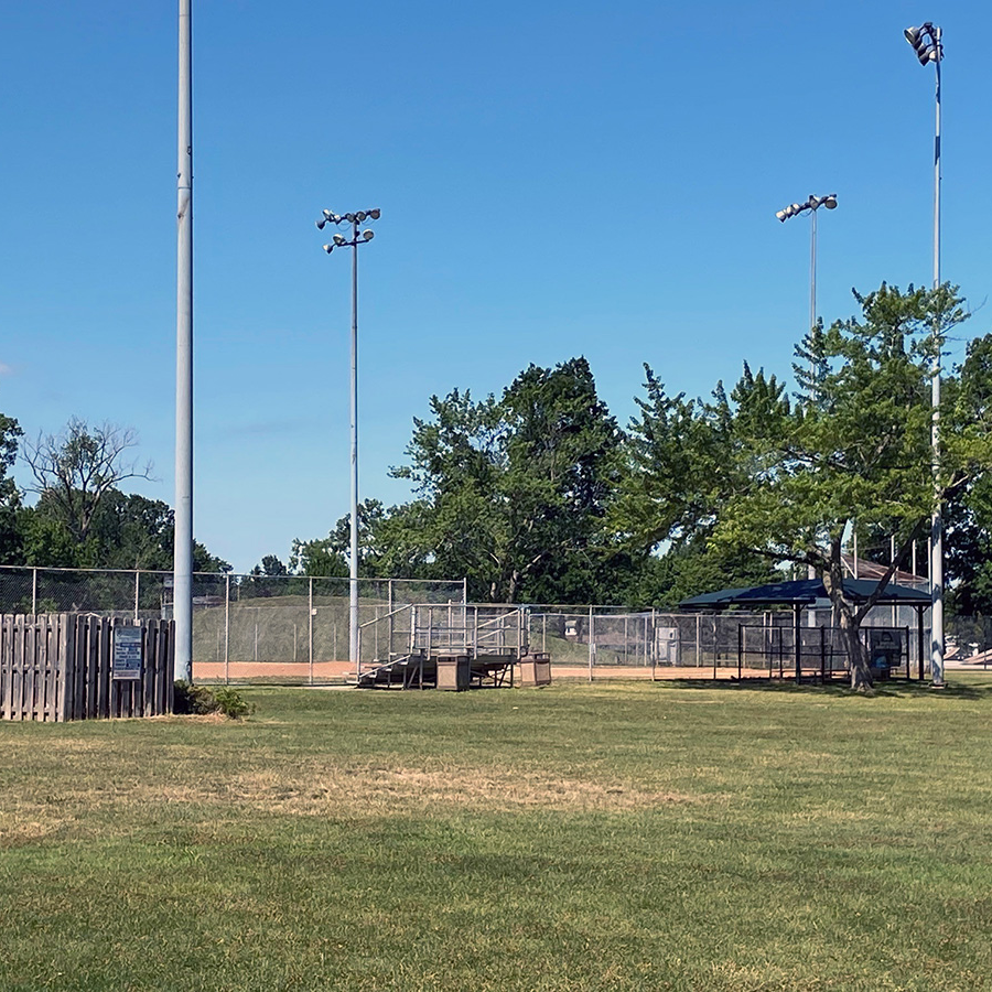 baseball field with bleachers and light poles