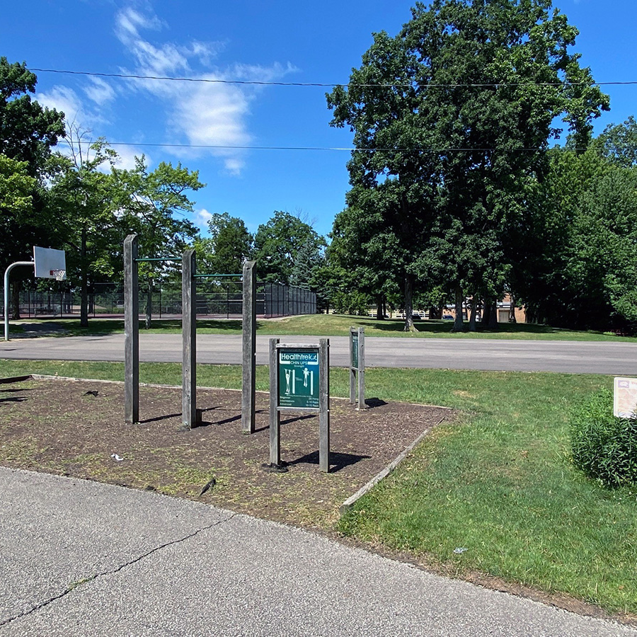 park fitness equipment in front of basketball court with asphalt surface