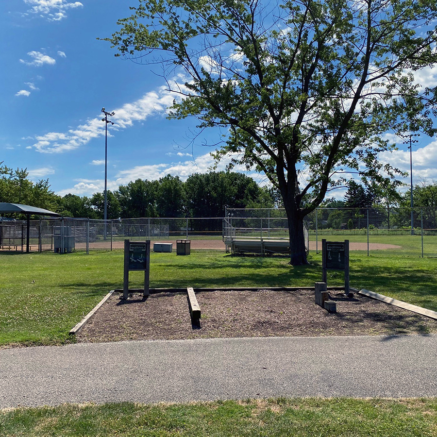 park fitness equipment in front of baseball field with bleachers