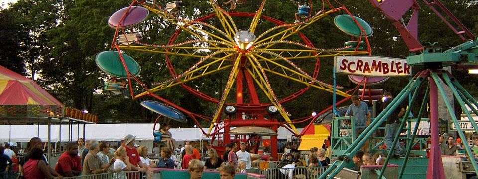 multi colored ferris wheel with people watching festival