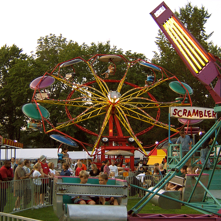 multi colored ferris wheel with people watching festival