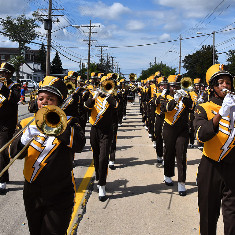 Brush marching band with gold & brown uniforms playing horns