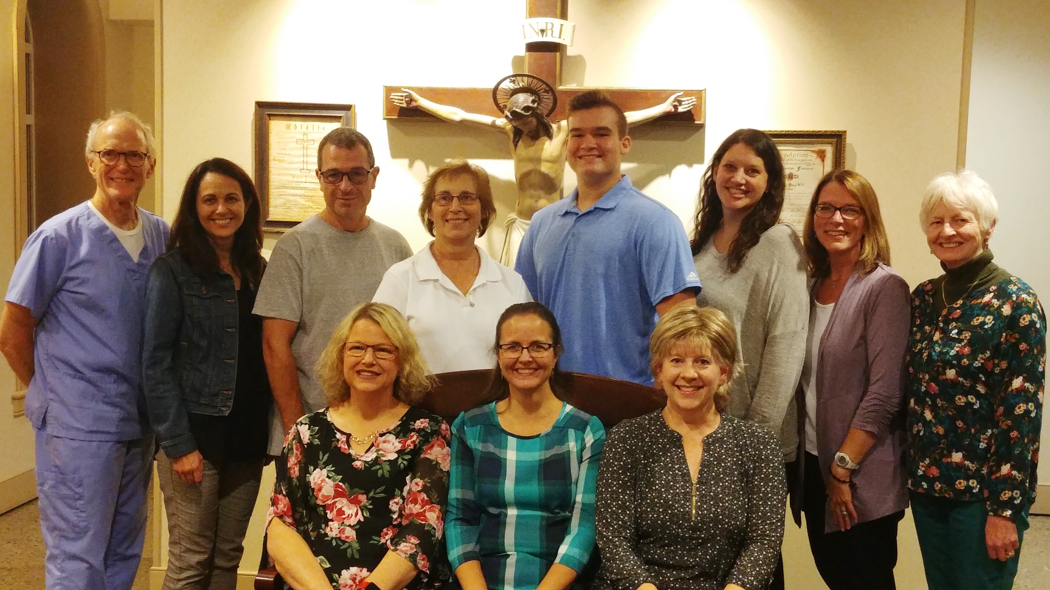 Group of people standing in front of large crucifix