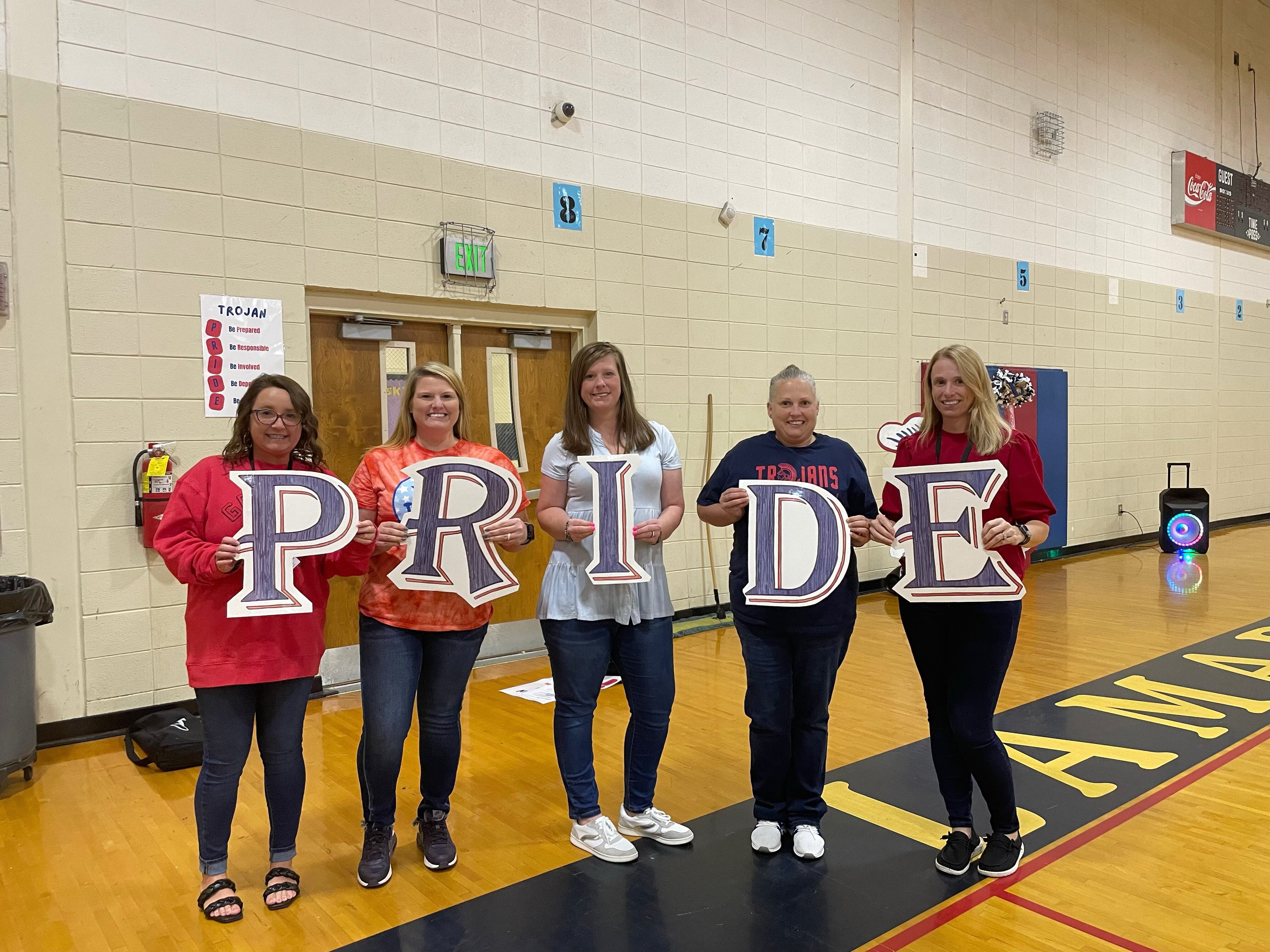 Teachers holding signs that say pride