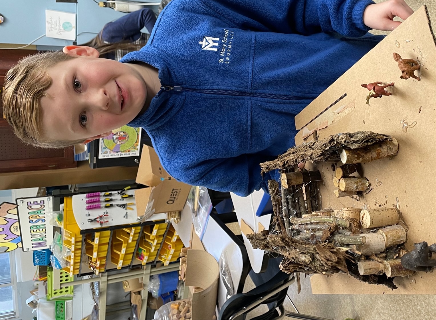 boy displaying his longhouse project