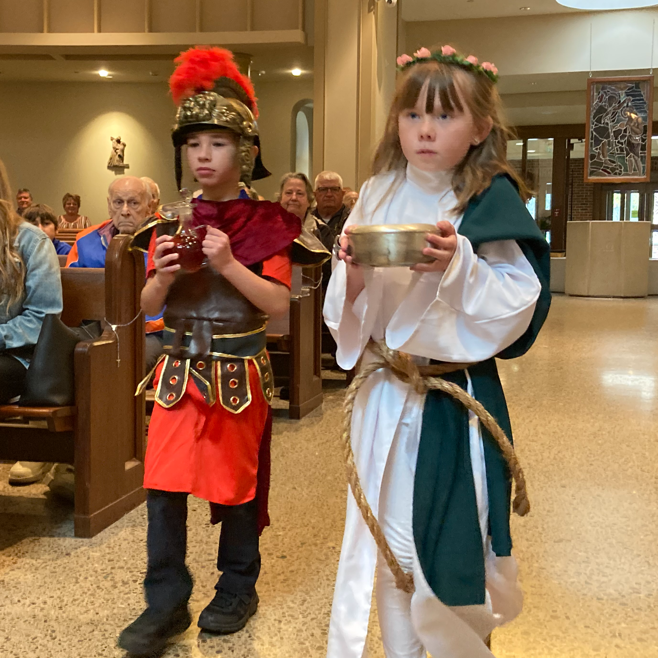 Students dressed as saints with wine and hosts