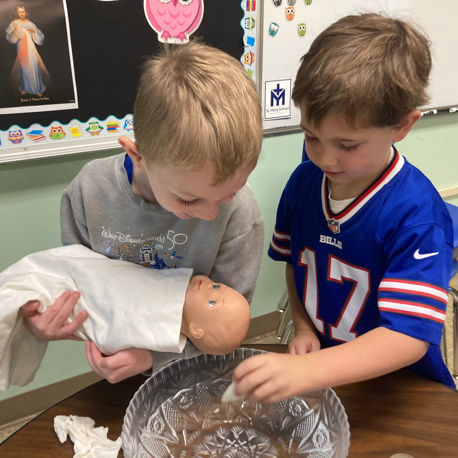 Little boys baptizing a baby doll