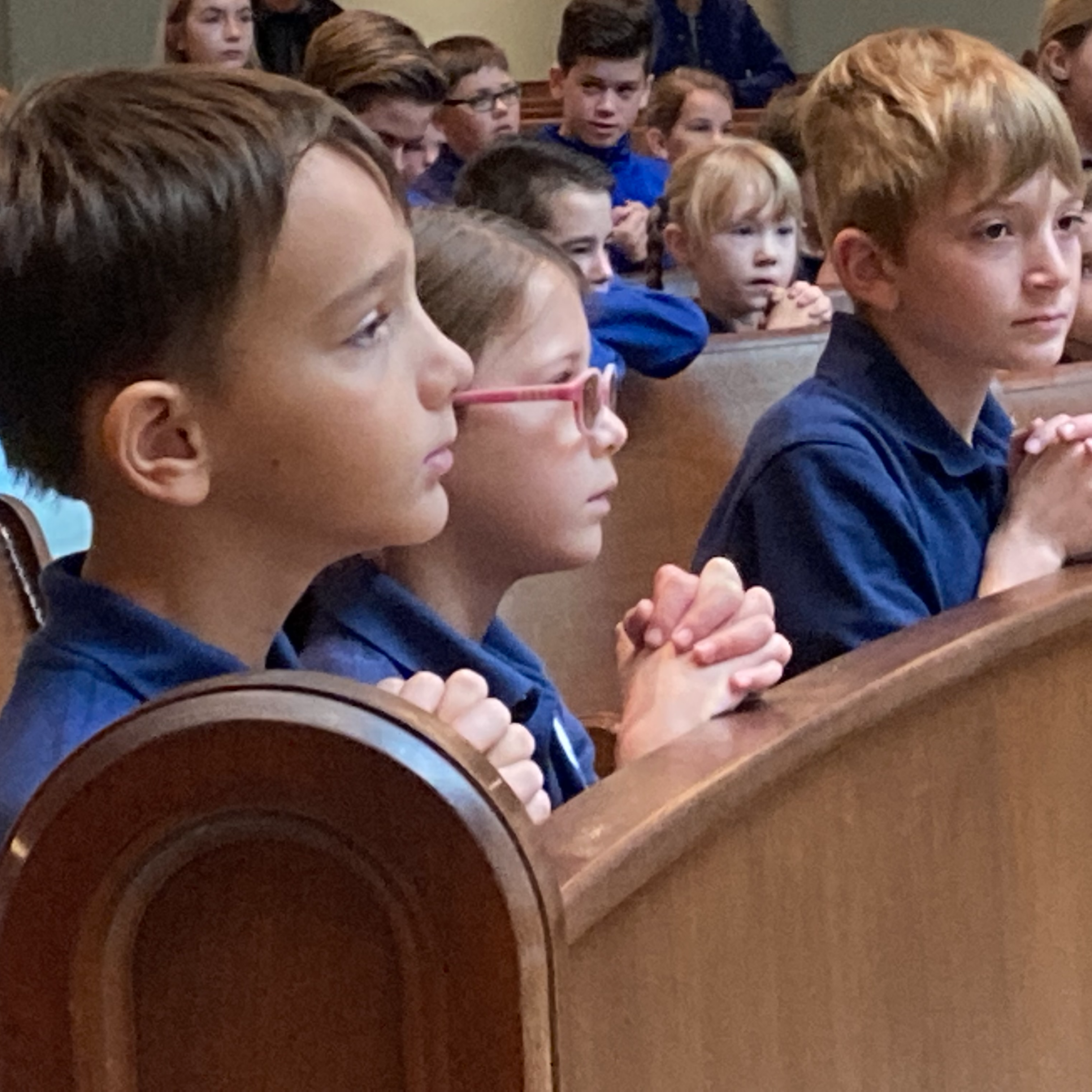 children kneeling in a church pew