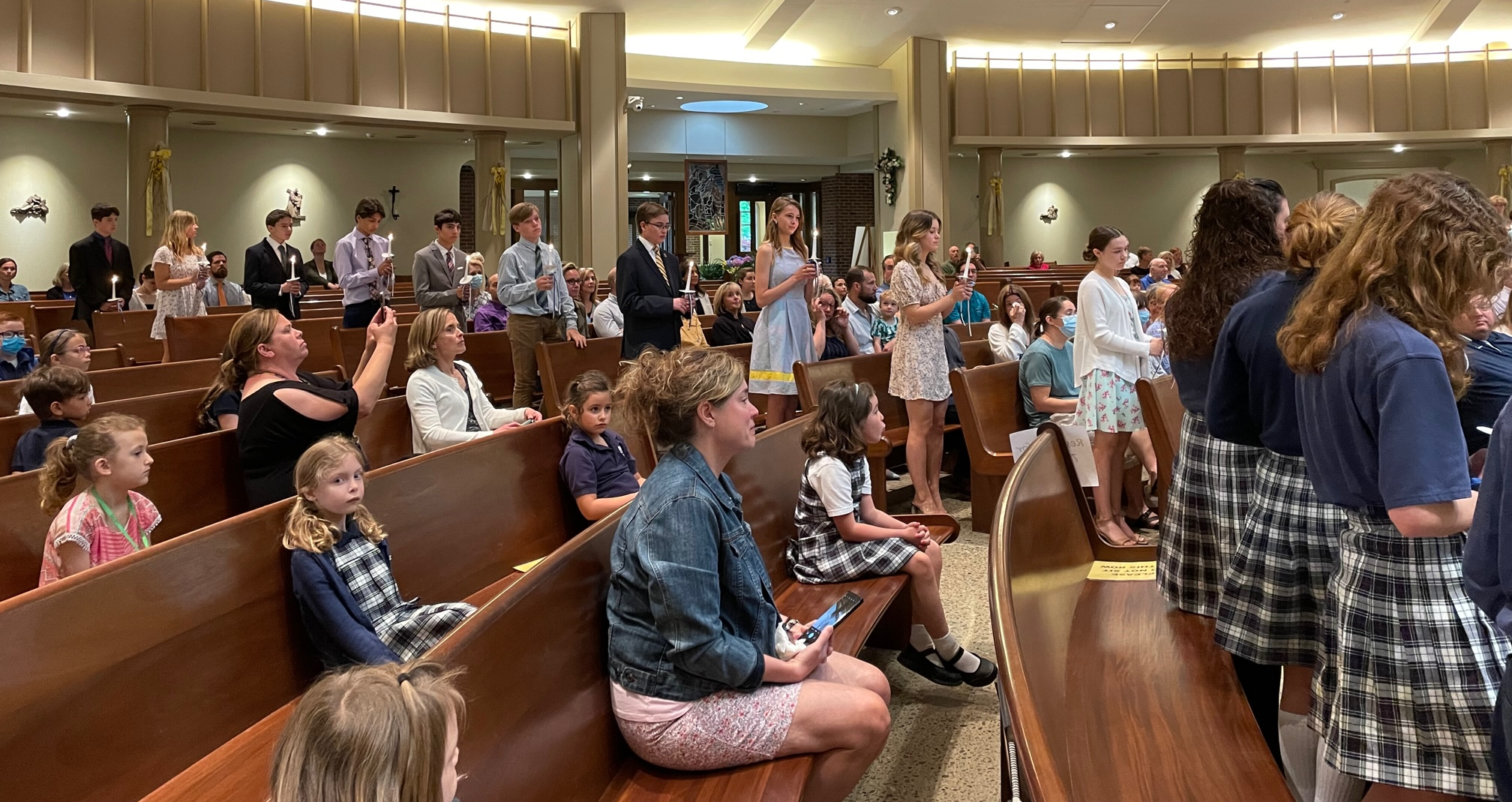 students at Mass with candles