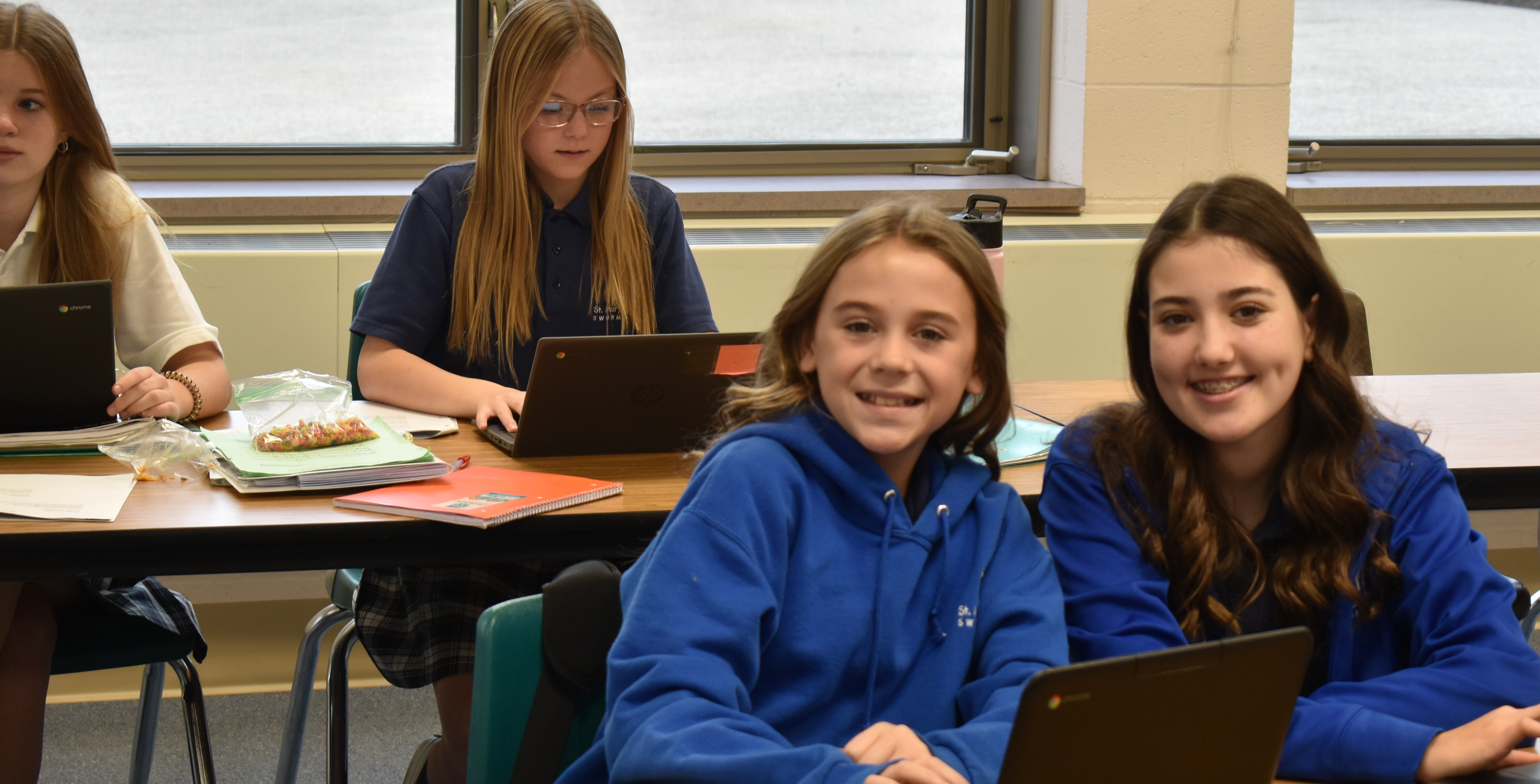 smiling girls on computers in classroom