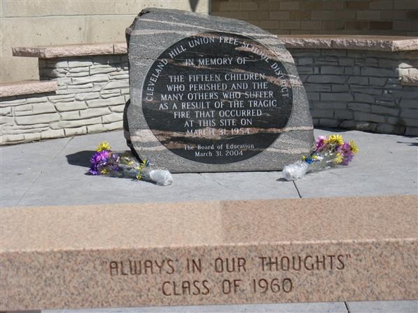 Image of fire memorial stone and bench in front of building